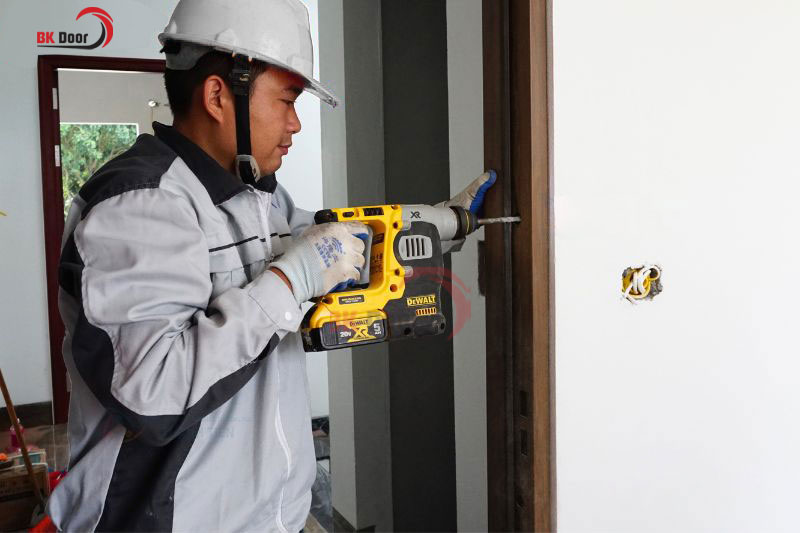 Nhân viên kỹ thuật BK Door thi công cửa thép vân gỗ tại Hà Nội