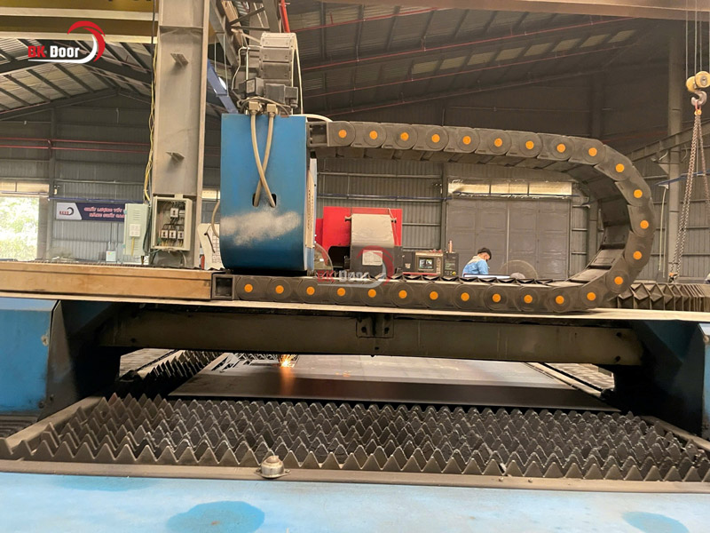 Máy cắt Laser CNC là một công đoạn quan trọng trong dây chuyền công nghệ sản xuất cửa thép vân gỗ